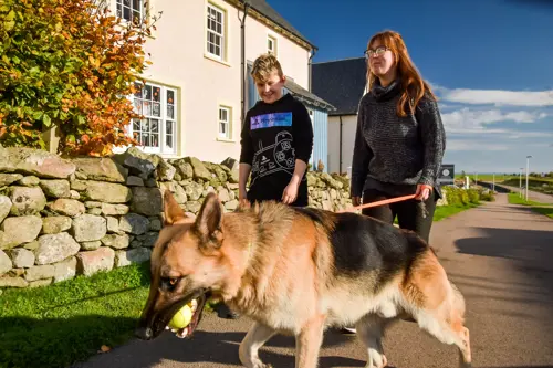 Two people walking with dog